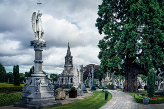 Dublin, Ireland, August 2019 Sculpture and monument of archangel, crypts, graves and tombstones with Celtic crosses in Glasnevin Cemetery