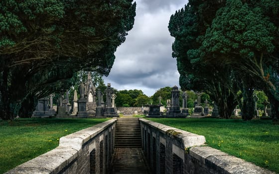 Dublin, Ireland, August 2019 Stairs leading out from crypt, ancient graves and tombstones with Celtic crosses in Glasnevin Cemetery