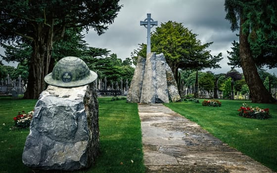 Dublin, Ireland, Aug 2019 Irish infantry helmet with Celtic Cross as a memorial of fallen soldiers who fought in both World Wars, Glasnevin Cemetery