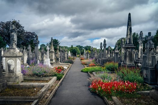 Dublin, Ireland, August 2019 Ancient graves with Celtic crosses and sculptures in Glasnevin Cemetery with dramatic storm sky in background