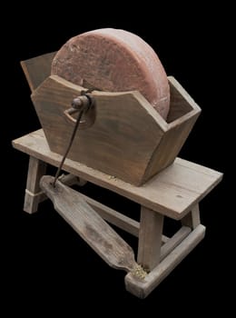 Antique pedal-powered sharpening machine. Isolated over black background