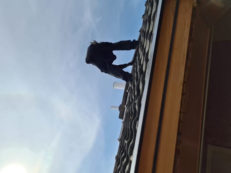 A professional roofer repairs the roof
