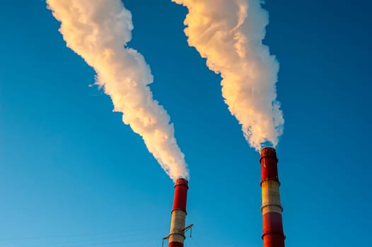 white smoke is coming out of the pipes in the blue sky. High quality photo