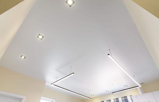 Modern white matte stretch ceiling with zoned lighting