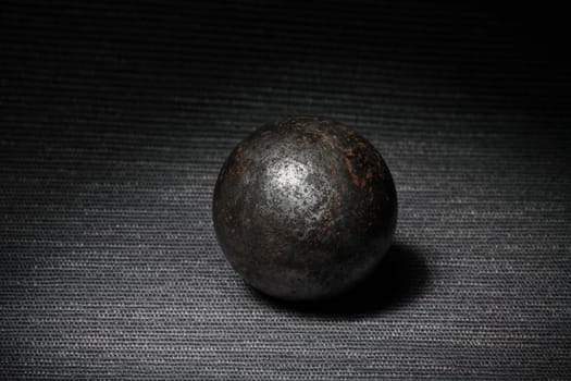 steel rusty ball on a dark background, still life