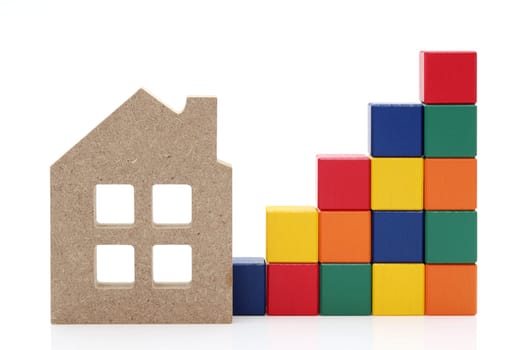 small toy house and wooden colorful building blocks on white background