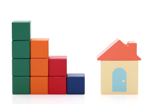 small toy house and wooden colorful building blocks on white background