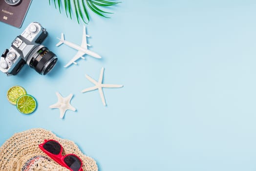 Flat lay top view mockup retro camera films, airplane, starfish, shells, hat traveler tropical accessories on a blue background with copy space, Business trip, and vacation summer travel concept