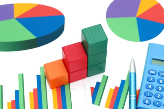 colorful wooden blocks with graph printed documents on white background