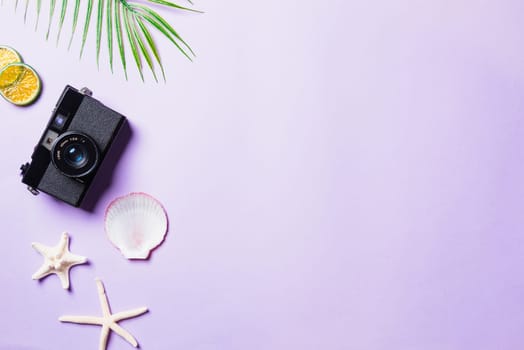 Top view flat lay mockup of camera films, shells, leaves, starfish beach traveler accessories on a purple background with copy space, Business trip, and vacation summer travel concept