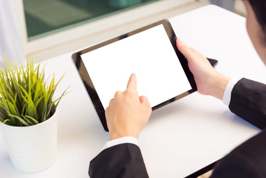 Work from home, Back view of Asian young businessman smile wearing suit video conference call or facetime by smart digital tablet computer he use finger touch on blank screen of tablet on desk