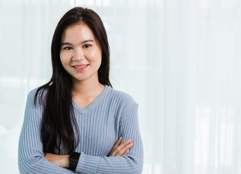 Close up headshot portrait young Asian happy beautiful woman healthy smiling face long hair stand crossed arm, studio shot looking to camera at home and have a copy space
