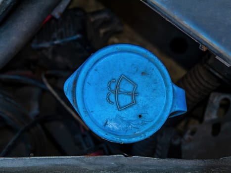 Tank cap for filling the windshield washer of the car. Plastic canister lid. Washer fluid reservoir. Car repair. Service maintenance. Vehicle repair. Repair shop. Part of a vehicle.