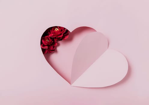 Love message, Saint Valentine Day conceptual flat lay. Top view on cut, curved paper pink heart shape on pink background. Minimal mockup for valentine card, invitation, greeting card. Red rose flower