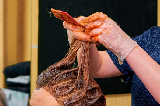 The process of painting women's hair in a barber shop close-up. High quality photo