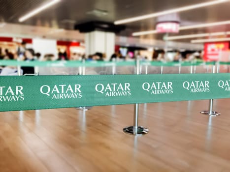 Doha, Qatar, July 2021: Green belt barrier with the Qatar Airways logo. Qatar Airways is the flag carrier airline of Qatar. Travel and airport security