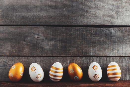 Easter holiday conceptual background on rustic wooden boards. Top view from above to different Easter eggs flat lay. Card with copy space to place text. Minimal concept. High quality photo