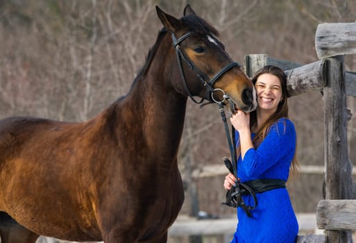 The horse caresses and bites the hand of a young beautiful girl