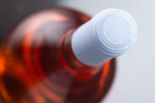 top view closeup of rose wine bottle mockup with light blue blank cap enclosure in focus