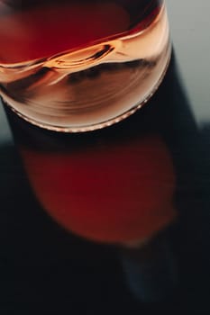 front view closeup of a rose wine bottle punt with reflection on shiny dark surface