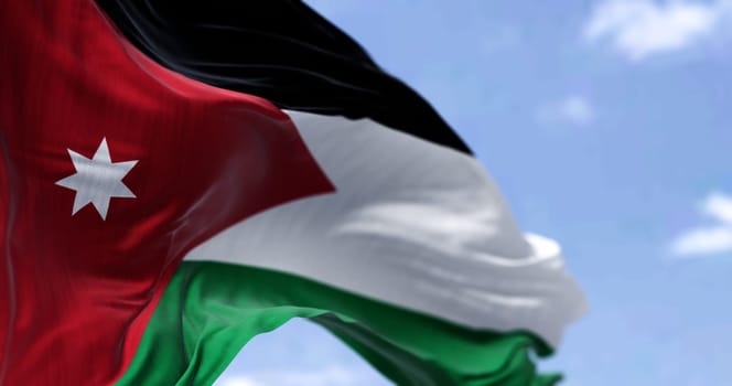 Detail of the national flag of Jordan waving in the wind on a clear day. Patriotism. Selective focus. Western asian country.