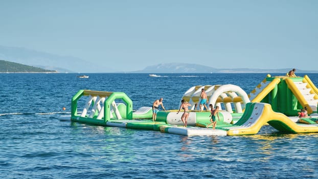 Holidaymakers have fun swimming in a bay near the town of Krk on the Adriatic Sea in Croatia