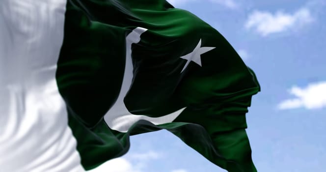 Detail of the national flag of Pakistan waving in the wind on a clear day. Democracy and politics. Patriotism. Selective focus. South Asian country.