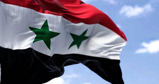 Detail of the national flag of Syria waving in the wind on a clear day. Democracy and politics. Patriotism. Selective focus. Western Asian country.