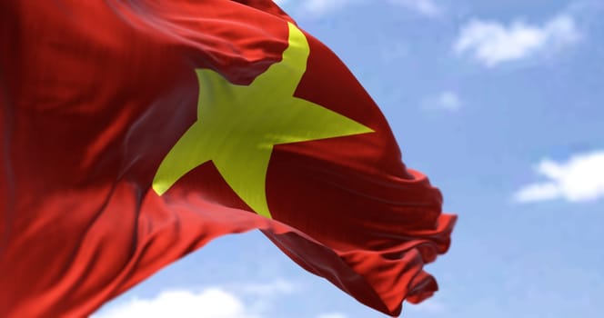 Detail of the national flag of Vietnam waving in the wind on a clear day. Socialist Republic. Patriotism. Selective focus. Southeast asian country.