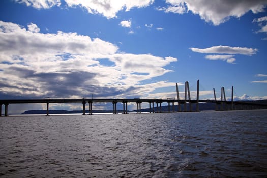 The long Governator Cuomo Bridge with clouds and blue sky on the Hudson river in the New York State