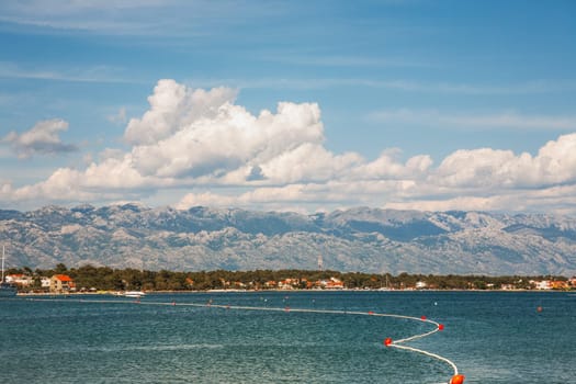 Beautiful coast, blue sea and mountains in the distance. Nice view of the blue Adriatic sea during a sunny day.