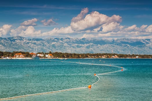 Beautiful coast, blue sea and mountains in the distance. Nice view of the blue Adriatic sea during a sunny day.
