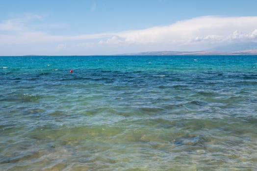 Beautiful coast, blue sea and mountains in the distance. Nice view of the blue Adriatic sea during a sunny day.