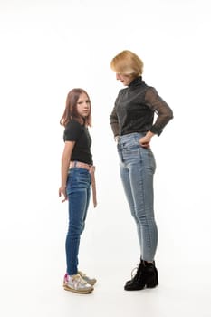 The mother reproachfully looks at the guilty daughter, the daughter looks sadly into the frame, isolated on a white background