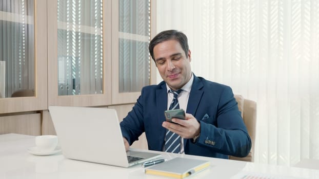 Business man sitting using laptop study online work at his desk success celebration at office, Smiling happy businessman cheerful in casual office making phone call while working with laptop computer
