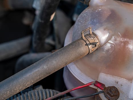 Metal clamp for fastening the rubber hose of the plastic tank of the car's coolant. Metal clamp. Rubber hose. Blasik tank. Liquid container. Antifreeze. Car repair. Service maintenance. Repair shop.