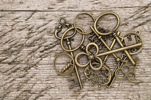 stack of golden vintage key on grungy wooden background