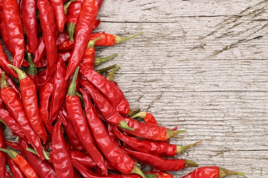 red chili pepper plants on grungy wooden background, copy space