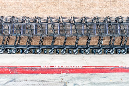 row of empty shopping carts in the big supermarket in California, USA