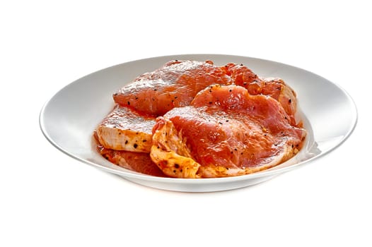 Pork in marinade lies on a white plate on a white isolated background. High quality photo