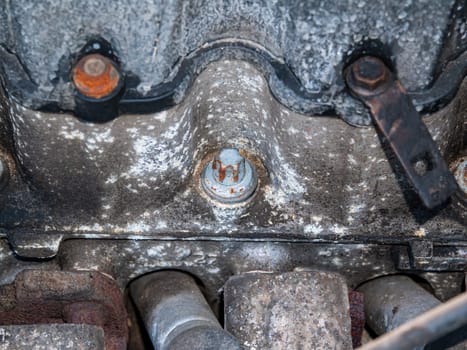 Old rusty metal car engine mounting bolt. Bolt and nut. Metal fastening. Threaded connection of steel parts. Engine part. Car repair. Transport service. Locksmith work. Repair shop.