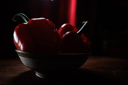 Two red pepper in bowl with red backround