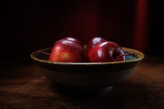4 red apples in clay bowl