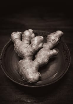 Ginger in handmade clay bowl on wooden table