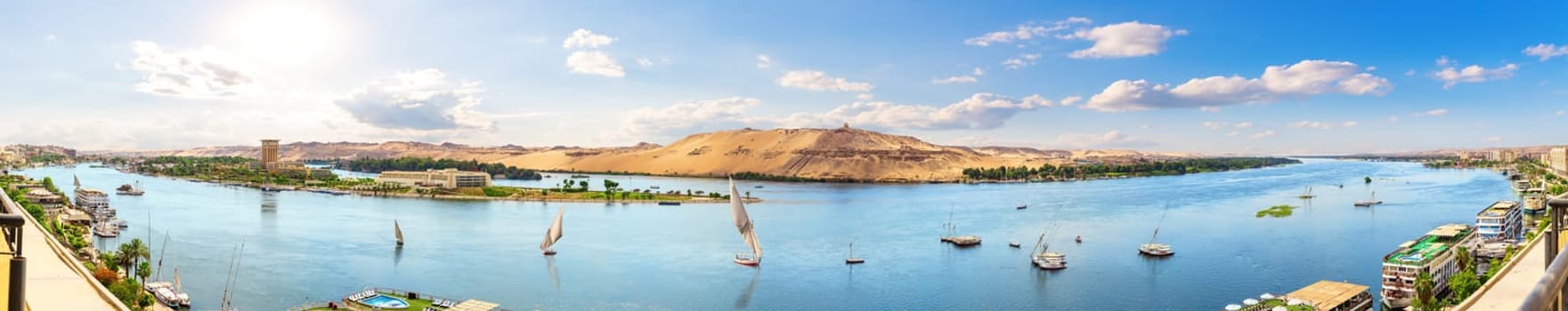 Full panorama of the Nile and sailboats by the banks of Aswan, Egypt.