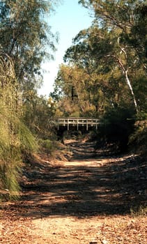 Old style suspended footbridge over a dry creek