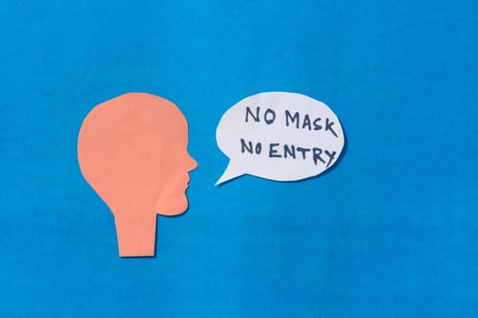 Paper Human face with No Mask No Entry sign on speech bubble isolated on blue background. Conceptual images showing that a person must accepts the conditions of wearing a mask before entering.