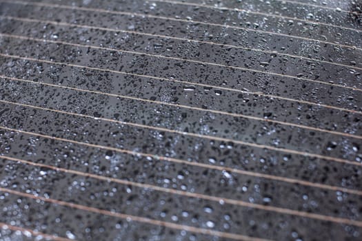 Drops of water on rear car window, heating stripes visible.