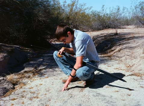 Young archer with a traditional long bow tracking an animal
