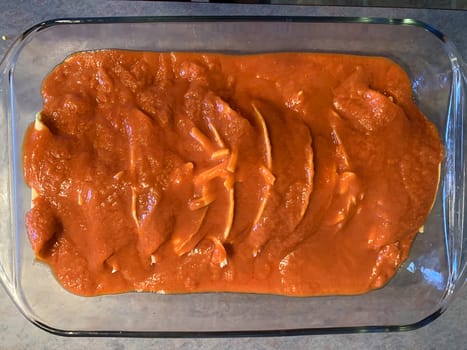 Chicken enchiladas in red chile sauce preparation